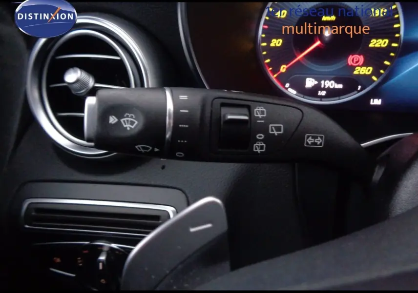 Gros plan sur la commande d’essuie-glace à gauche du volant dans l’habitacle noir du Mercedes Classe C Break 220D AMG Line.