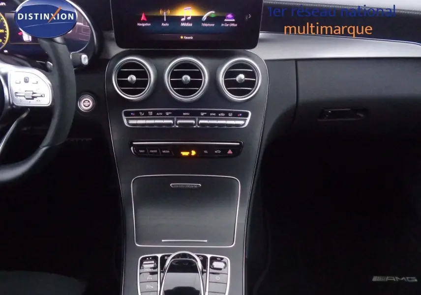 Vue intérieure centrée sur la console et le volant d'une Mercedes Classe C Break 220D noire avec finition AMG Line.