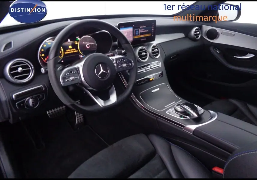 Vue intérieure côté conducteur d'une Mercedes Classe C Break 220D AMG Line 2021 avec tableau de bord noir et écran central.