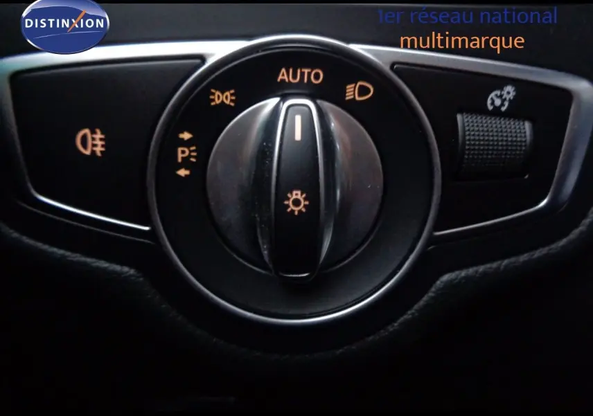 Gros plan sur la molette de réglage des phares avec fonction automatique, dans une Mercedes Classe C Break noire.