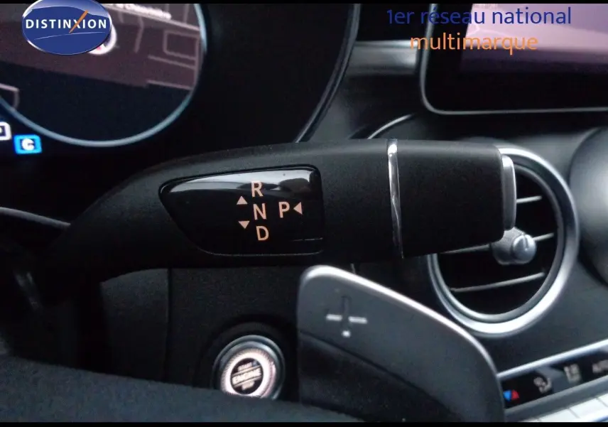 Gros plan sur la commande de boîte automatique à levier droit dans l'habitacle noir d'une Mercedes Classe C Break 220D AMG Line.