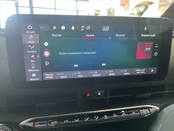 Écran tactile central de la Fiat 500 électrique gris minéral, affichant la radio DAB et commandes climatisation en dessous.