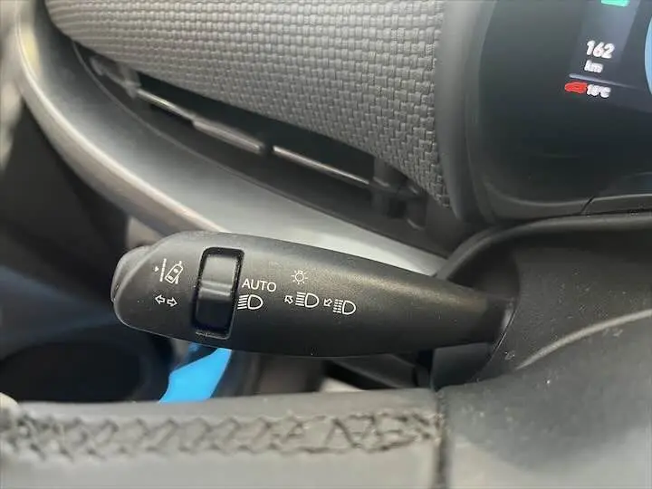Gros plan sur la commande des feux et clignotants à gauche du volant du Fiat 500 électrique gris minéral.