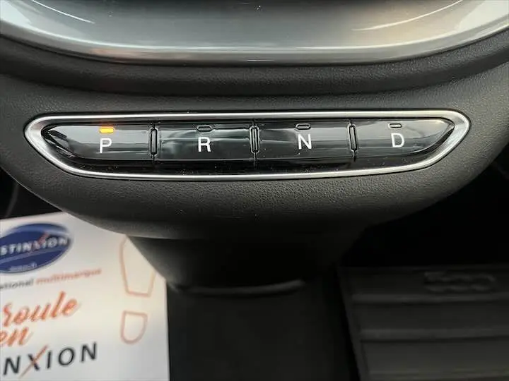 Gros plan sur la console centrale de la Fiat 500 électrique gris minéral, montrant les boutons de sélection de la boîte automatique.