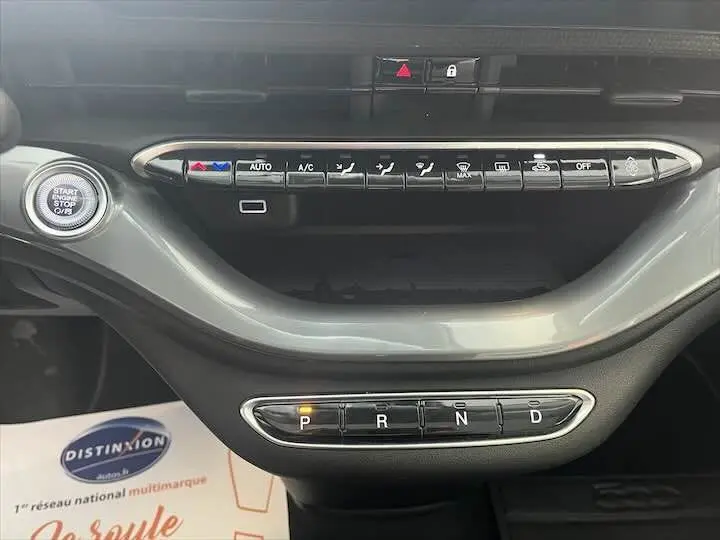 Console centrale de la FIAT 500 électrique gris minéral, avec commandes climatisation et sélecteur de vitesse automatique.