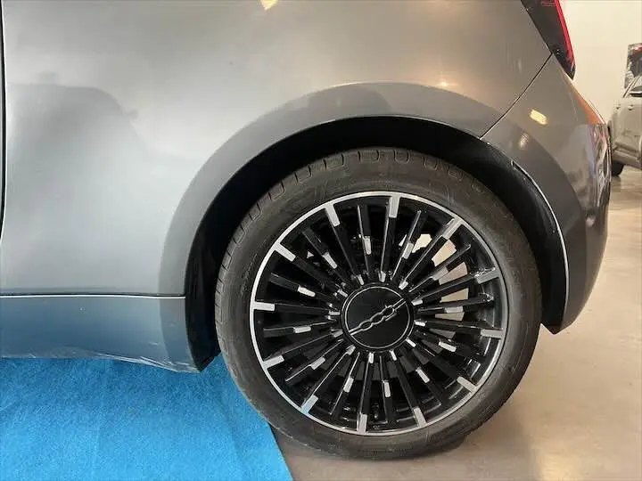 Gros plan sur la roue arrière droite de la FIAT 500 électrique gris minéral métal avec jante noire et argentée design moderne.
