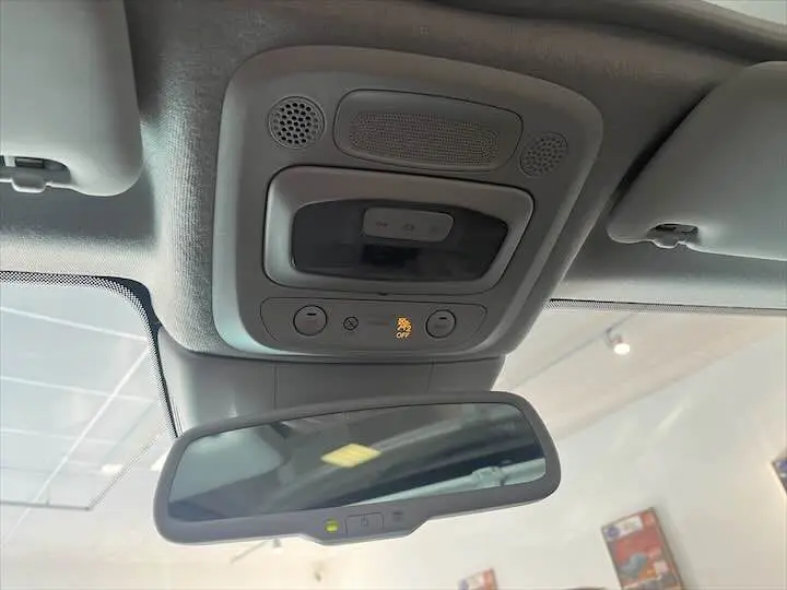 Vue rapprochée du plafonnier et du rétroviseur intérieur d'une FIAT 500 électrique gris minéral métal, avec témoin d'alerte allumé.