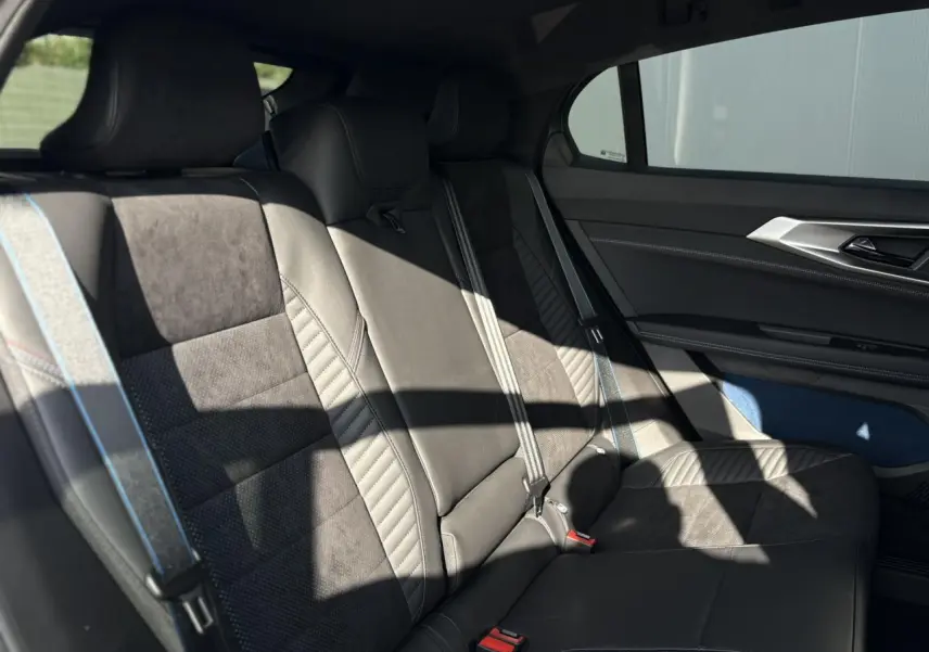 Banquette arrière en cuir et textile gris avec surpiqûres bleu, blanc, rouge dans une Renault Rafale E-Tech 2025.
