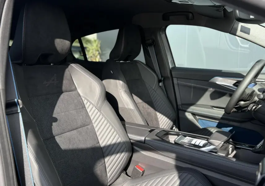 Intérieur avant de la Renault Rafale E-Tech gris schiste, sièges sport avec surpiqûres bleues et console centrale moderne.