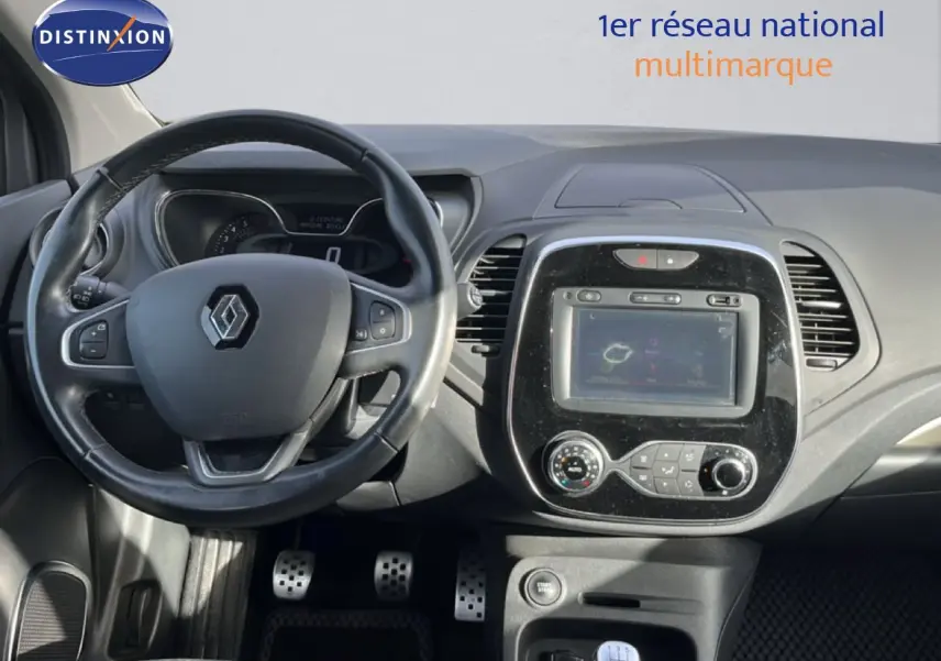Vue intérieure centrée sur le volant et la console centrale du Renault Captur gris, version Intens 2019 avec boîte manuelle.