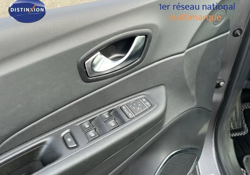 Vue rapprochée de la porte avant gauche grise du Renault Captur 2019 avec commandes électriques des vitres et poignée chrome.