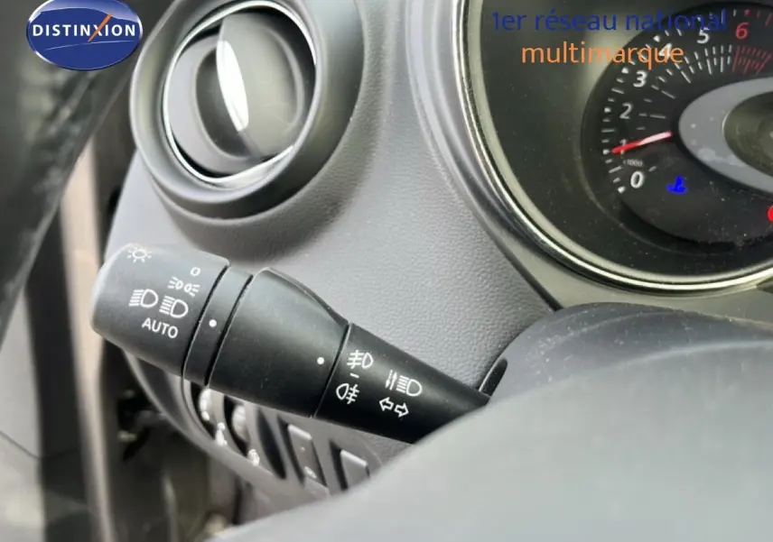 Gros plan sur la commande des phares à gauche du volant du Renault Captur gris, tableau de bord partiellement visible.