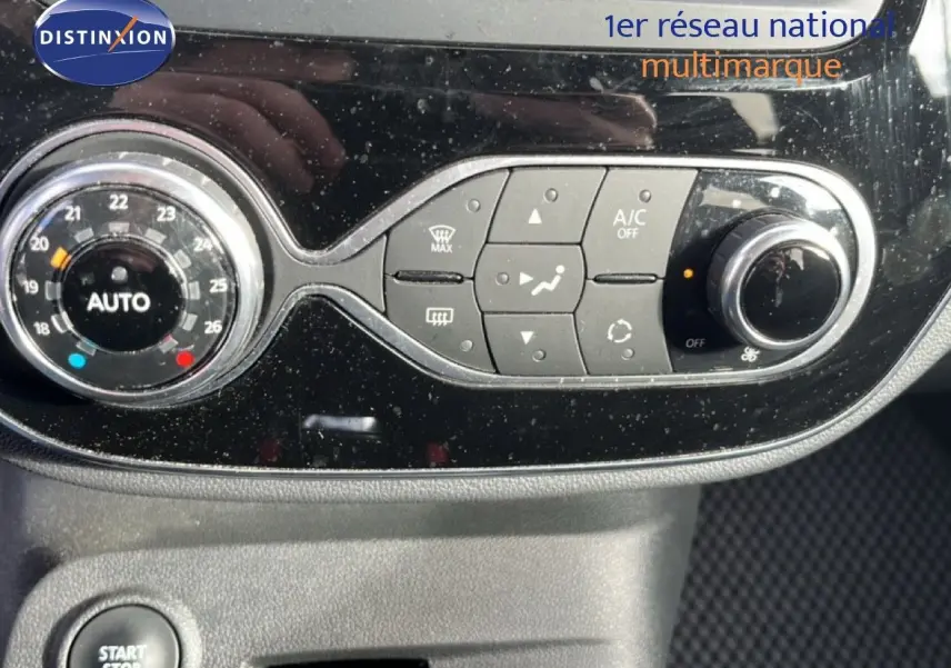 Gros plan sur la console centrale du Renault Captur gris 2019, montrant les commandes de climatisation et le bouton start/stop.