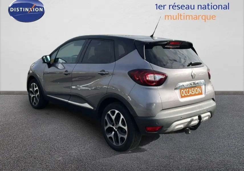 Vue 3/4 arrière droite d’un Renault Captur gris 2019 avec attelage et jantes alliage distinctives.