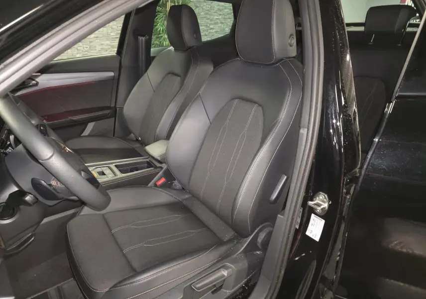 Vue intérieure côté conducteur du CUPRA Formentor noir, sièges sport bimatière avec surpiqûres cuivrées visibles.