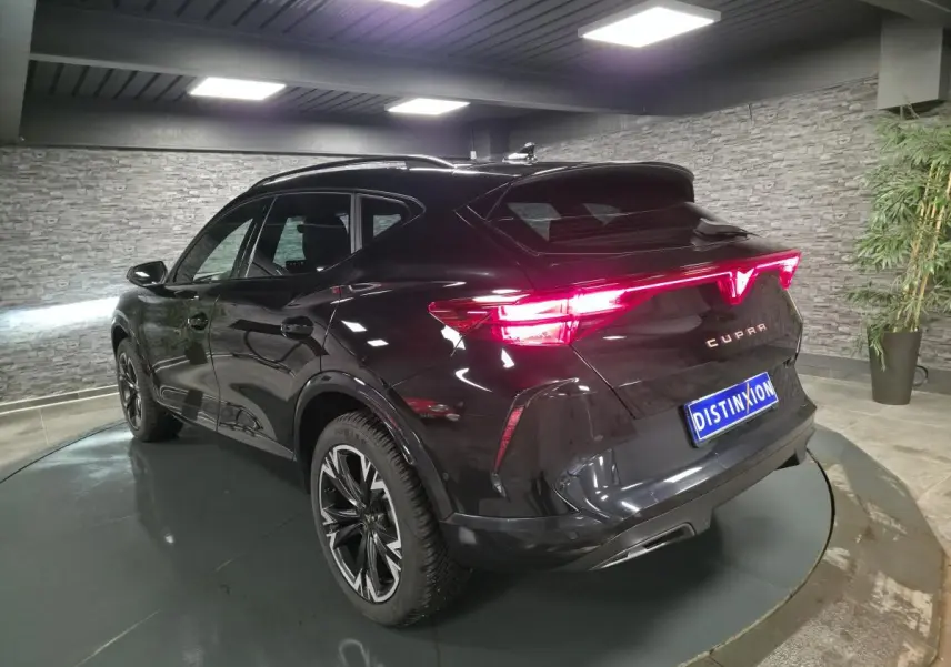 Vue 3/4 arrière droite d'un CUPRA Formentor noir avec feux arrière Tri-LED et jantes alliage 18'' usinées.