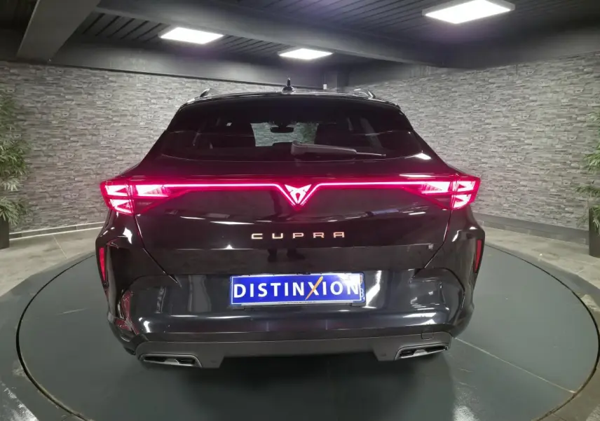 Vue arrière d'un CUPRA Formentor noir 2025 avec signature lumineuse LED en bandeau et double sortie d'échappement.