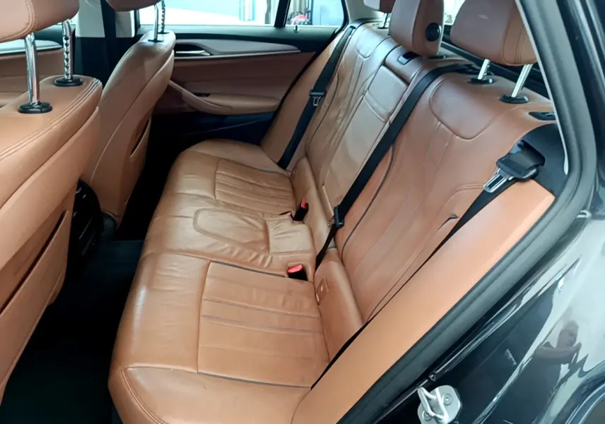 Vue côté droit de la banquette arrière en cuir marron clair d'une BMW Série 5 Touring 530e 2022.