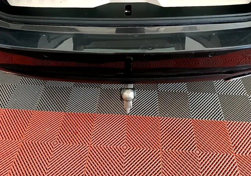 Vue rapprochée de l'attelage de remorque sous le pare-chocs arrière gris clair d'une BMW Série 5 Touring 530e 2022.