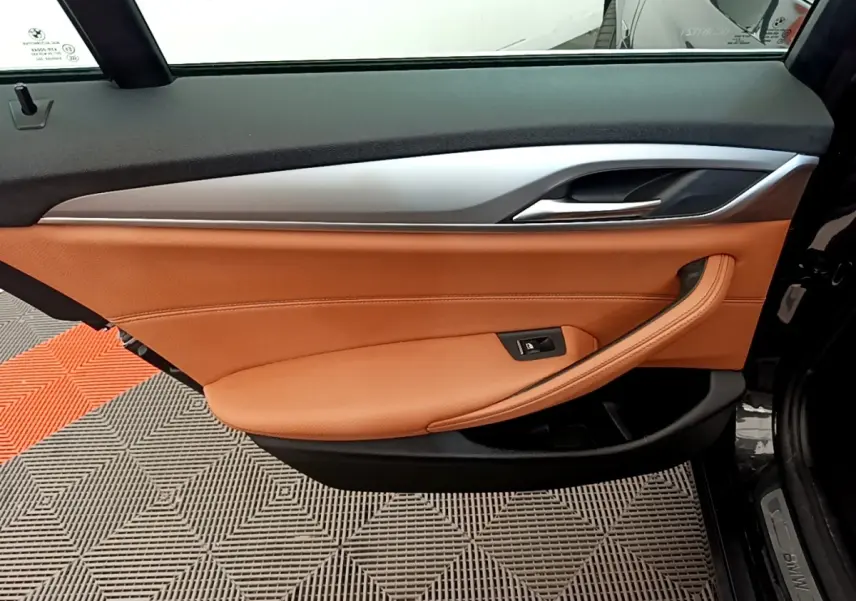 Intérieur de la porte avant droite de BMW Série 5 Touring 530e 2022, cuir marron et garniture aluminium.