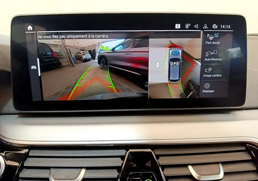 Écran tactile intérieur montrant l'aide au stationnement avec vue caméra 360° dans une BMW Série 5 Touring gris clair.