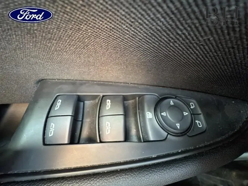 Détail des commandes de lève-vitres et réglage des rétroviseurs sur la porte côté conducteur d’une Opel Insignia Sports Tourer gris minéral.