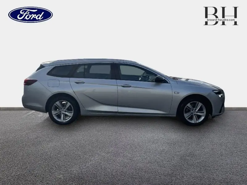 Profil droit d'une Opel Insignia Sports Tourer gris minéral métallisé, break élégant aux lignes fluides et jantes alu.