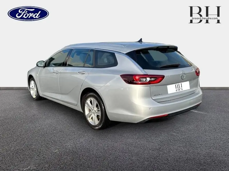 Vue 3/4 arrière droite d'une Opel Insignia Sports Tourer gris minéral métallisé avec feux arrière LED et jantes alu.