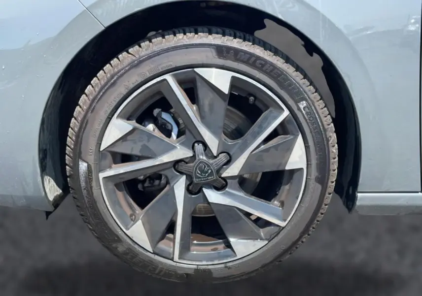 Gros plan sur la roue arrière droite grise d'une Peugeot 308 1.5 BlueHDi 130 Allure avec jante alu distinctive.