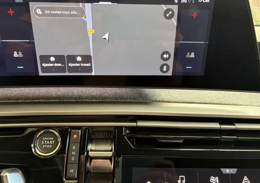 Vue rapprochée du tableau de bord du Peugeot 5008 hybride 2025, avec écran tactile et commande de boîte automatique.