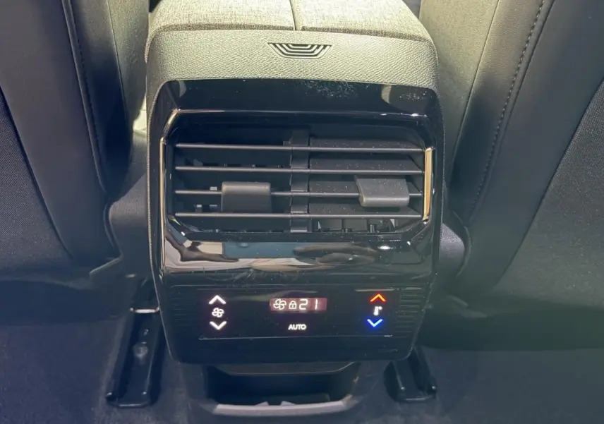 Détail de la commande de climatisation arrière noire du Peugeot 5008 Hybrid 145 vue de face entre les sièges arrière.