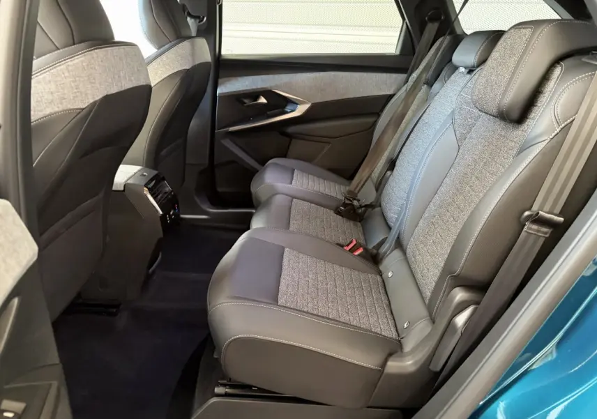Vue intérieure côté droit sur la banquette arrière grise et tissu du Peugeot 5008 vert avec porte ouverte.