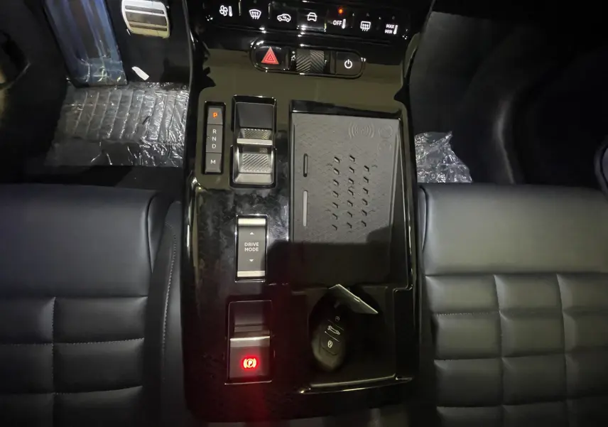 Vue plongeante sur la console centrale noire brillante du Citroën C5 Aircross hybride avec levier de vitesses et clé posée.