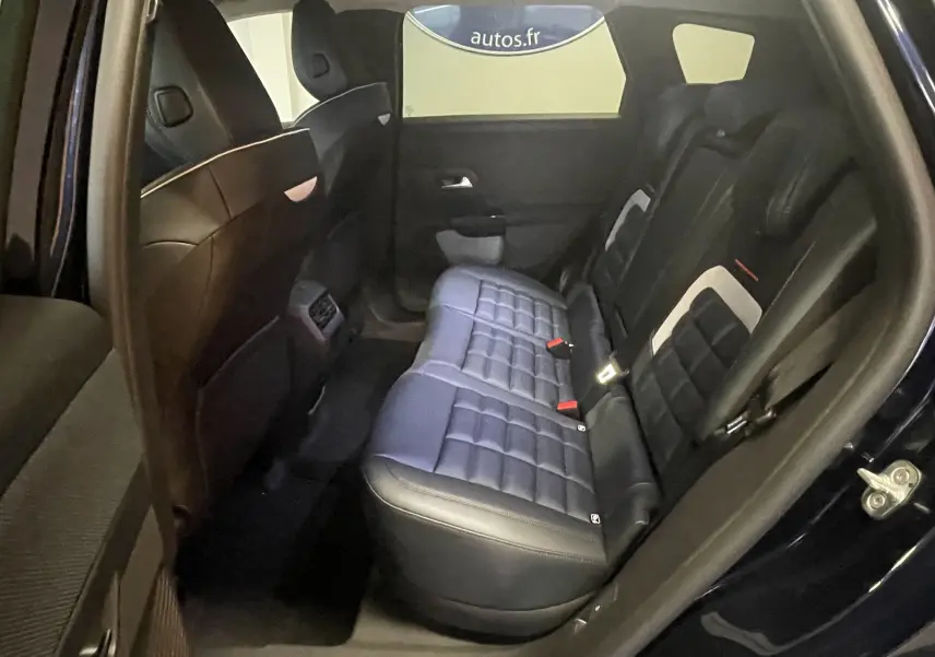 Vue intérieure côté droit des sièges arrière en cuir noir du Citroën C5 Aircross hybride 2026 avec détails blancs.