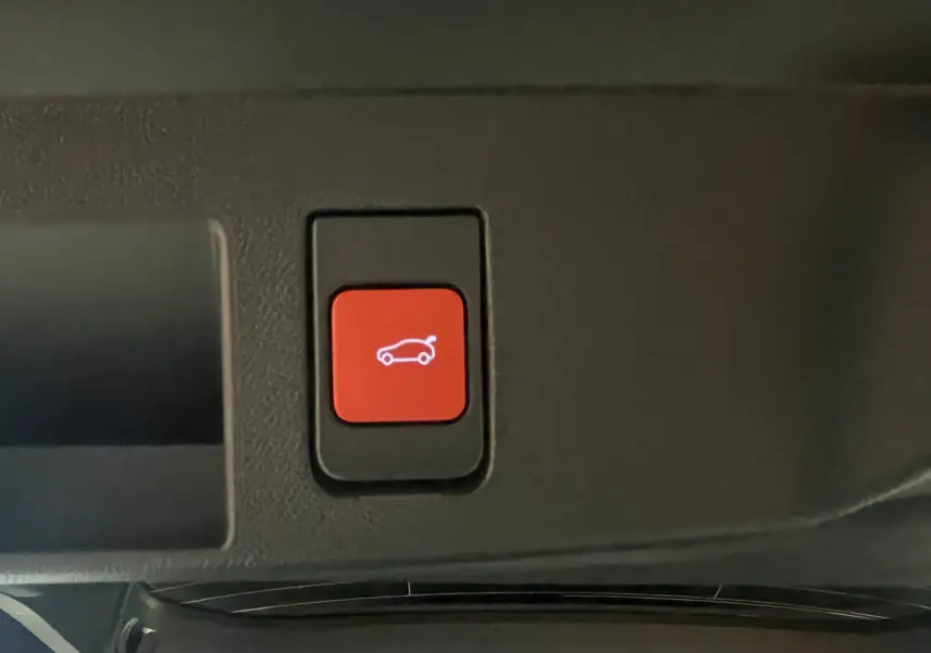 Bouton rouge d'ouverture du coffre dans l'habitacle du Citroën C5 Aircross hybride 2026.