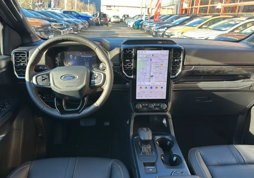 Vue intérieure avant du Ford Ranger gris carbone 2026, avec volant cuir multifonctions et écran tactile central vertical.
