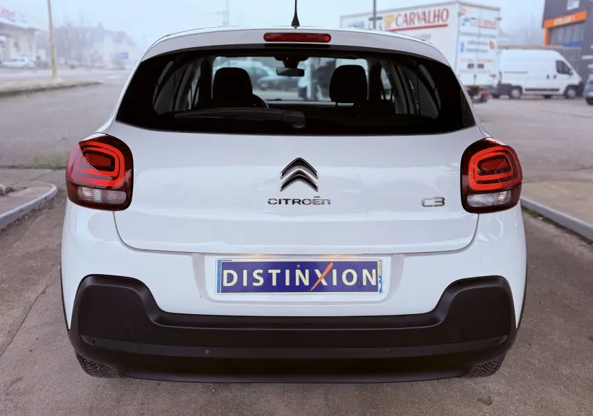Vue arrière d'une Citroën C3 blanche de 2019 avec feux arrière rouges et plaque d'immatriculation Distinxion.