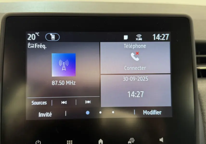 Écran tactile central de la Renault Clio noire 2025 affichant la radio FM et la connexion téléphone