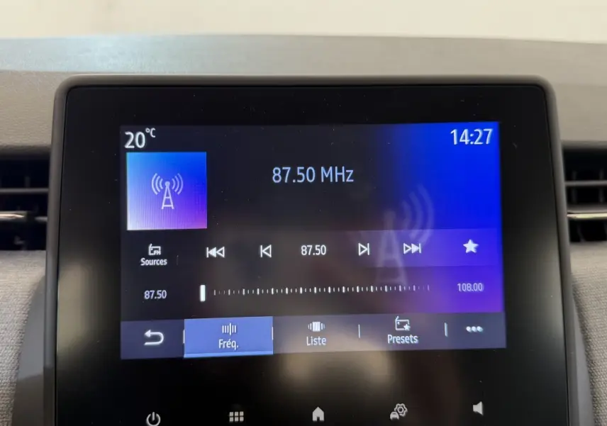 Écran tactile central de la Renault Clio noire 2025 affichant la radio FM à 87,50 MHz à 14h27.
