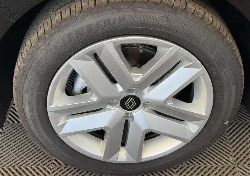 Gros plan sur la roue avant droite de la Renault Clio noire 2025, mettant en valeur la jante argentée au design moderne.