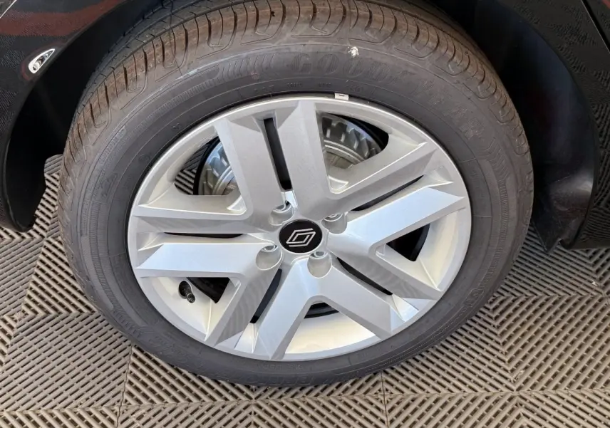 Gros plan sur la roue avant gauche de la Renault Clio noire, mettant en valeur la jante argentée au design moderne.