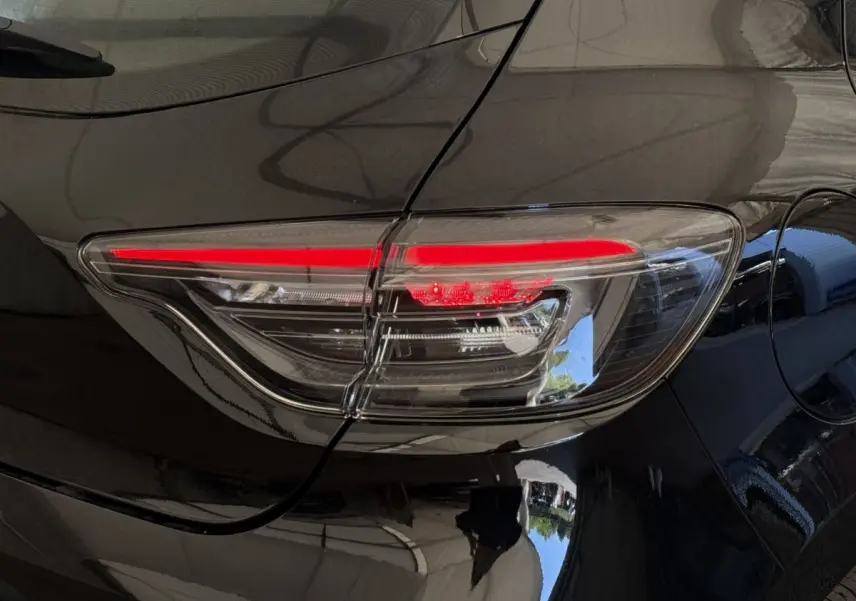 Gros plan sur le feu arrière droit rouge et blanc d'une Renault Clio noire Evolution Blue dCi 100 de 2025