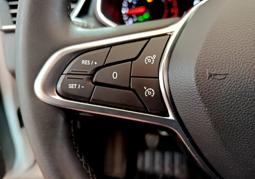 Gros plan sur le volant cuir synthétique noir de la Renault Clio Business TCe 100 avec commandes de régulateur de vitesse.