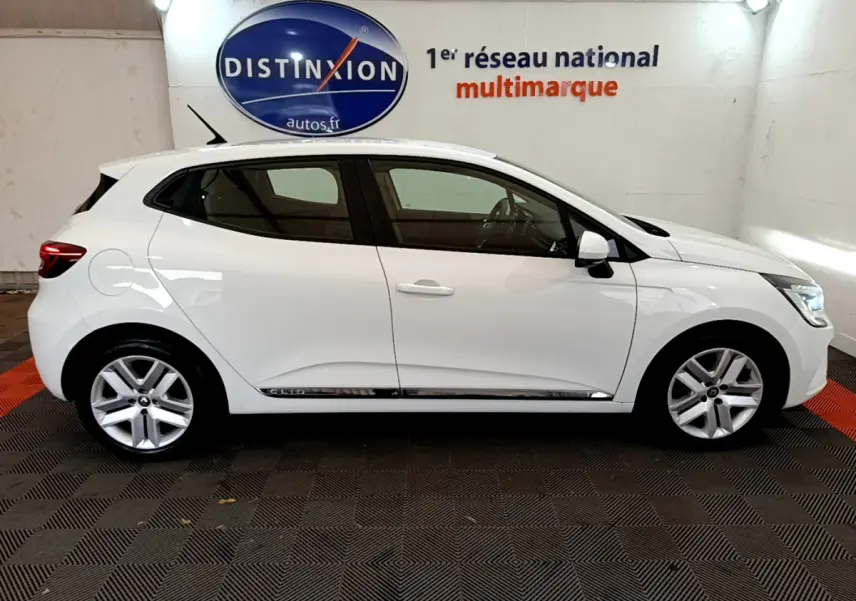 Profil côté gauche d'une Renault Clio Business TCe 100 blanche, avec jantes alliage et poignées de porte assorties.