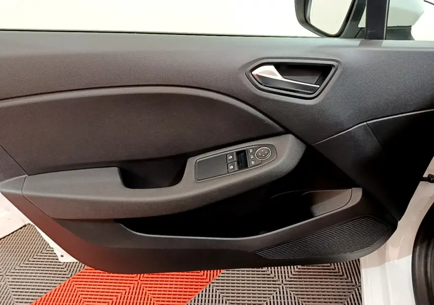 Vue intérieure du panneau de porte côté conducteur de la Renault Clio Business TCe 100 blanc, avec commandes électriques des vitres.