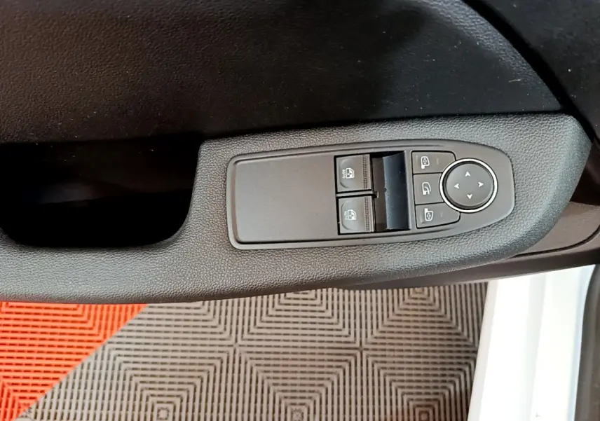 Commandes des vitres électriques et rétroviseurs sur la porte côté gauche d'une Renault Clio Business blanche de 2020.
