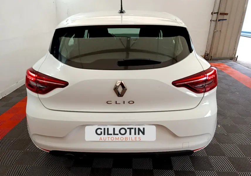 Vue arrière d'une Renault Clio blanche 2020 avec feux LED et logo Renault bien visibles dans un garage.