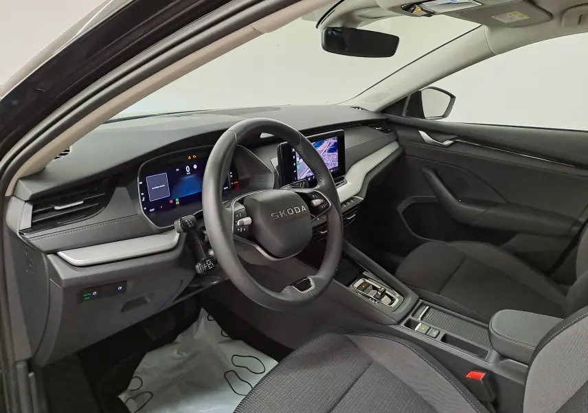 Vue intérieure côté conducteur de la Skoda Octavia Combi 2025, tableau de bord moderne avec écran tactile et volant multifonction.