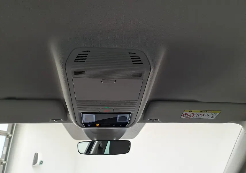Plafonnier intérieur gris clair avec commandes et rétroviseur, vue centrée vers l'avant dans une Skoda Octavia Combi 2025.