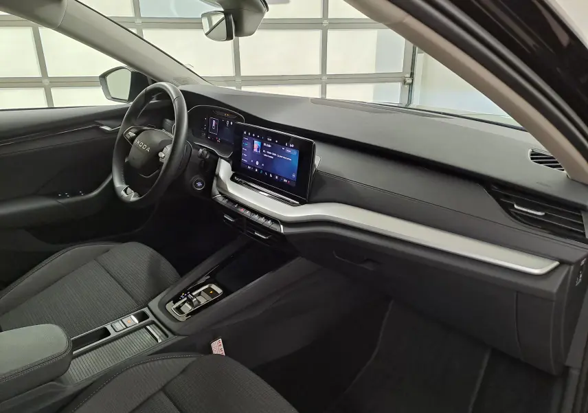 Vue intérieure côté conducteur de la Skoda Octavia Combi 2025 avec tableau de bord noir et écran tactile central.